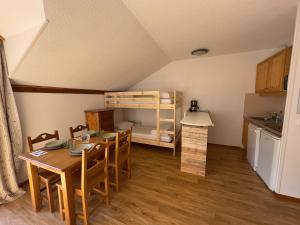 a kitchen and dining room with a table and a bunk bed at Les Orres 1800 - 6 pers - Piscine in Les Orres +21 photos