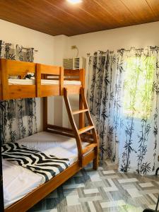a bedroom with two bunk beds and a window at 3Vhin Transient House in Sampong