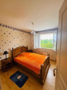 a bedroom with a large bed and a window at Maison située aux confins de la Vallée du Loir in Le Lude