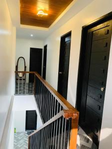 a room with a staircase with black doors and a balcony at 3Vhin Transient House in Sampong +4 photos