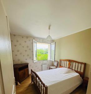 a bedroom with a bed and a window at Maison située aux confins de la Vallée du Loir in Le Lude +8 photos