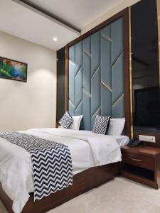 a bedroom with a large bed and a flat screen tv at Hotel sun park inn in Dehradun