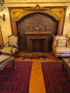 a living room with a fireplace and a chair at Legacy Lodge Heliopolis in Cairo
