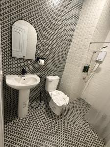 a bathroom with a sink and a toilet and a mirror at Natcha Hotel and Residence in Sathani Chumphon