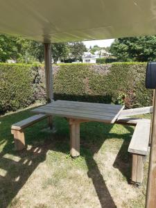 a picnic table under a tent in the grass at Camping Onlycamp Les Grenettes in La Varenne