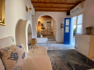 a living room with a couch and a blue door at Samanti Mykonos Sea View in Agios Ioannis Mykonos