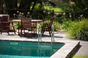 a patio with a table and chairs next to a pool at The Lodge at Seppeltsfield in Marananga