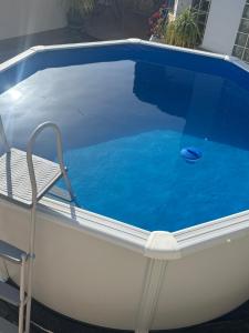 a swimming pool with a chair next to it at Apartamentos turísticos ilusiones in Cazalla de la Sierra