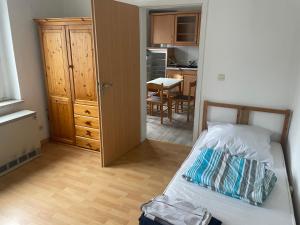 una piccola camera da letto con un letto e una cucina di Monteurwohnung Dajka a Solingen