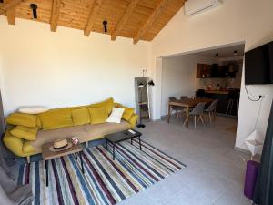a living room with a yellow couch and a table at Villa Godinovic in Hvar