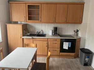 una cucina con mobili in legno, un tavolo e un lavandino di Monteurwohnung Dajka a Solingen Altre 2 foto