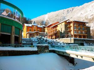 a town with snow covered buildings and a river at Maison de charme au cœur d'Ax-Les-Thermes in Ax-les-Thermes