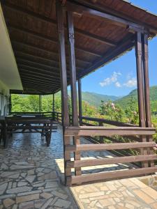 a pavilion with picnic tables and a view of the mountains at Valea Doamnei in Nucşoara