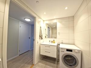 a bathroom with a washing machine and a sink at Modern brand new apartment Kongsberg in Kongsberg