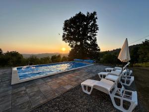 a group of white lounge chairs and a swimming pool at Villa Dalia in Gračanica +11 photos
