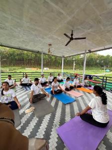 a group of people sitting on the floor in a yoga class at Mountain Valley in Jhājra +7 photos