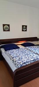 a bedroom with a bed with a blue comforter at Apartment Nevija e Natale in Opric