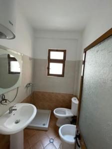 a bathroom with a sink and a toilet and a window at B Bibaj in Durrës