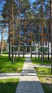 un sentiero in un parco alberato e un edificio di MONA Apartman Divčibare a Divčibare