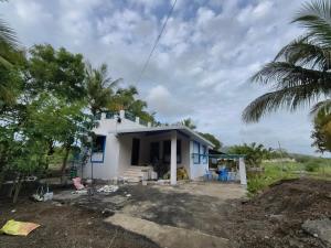 a house under construction with trees in the foreground at Krishna Garden and Resort in Betgaon +14 photos