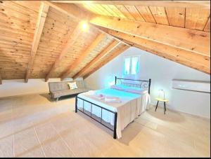 a bedroom with a bed and a couch in a attic at OLiVE HOUSE in Vathi