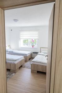 een slaapkamer met 4 bedden en een raam bij Sweethome Una Bihac in Bihać +10 foto's