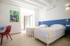 two beds in a room with a table and a chair at FarOut - BeachResort & Camping in Mylopotas