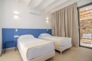 two beds in a hospital room with a window at FarOut - BeachResort & Camping in Mylopotas