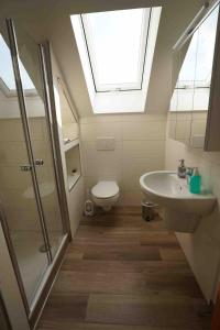 a bathroom with a toilet and a sink and a skylight at Bella Casa am Rhein in Bad Honnef am Rhein +17 photos