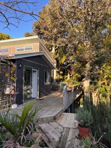 a house with a wooden deck next to a body of water at Queens Drive in Oneroa +28 photos