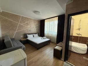 a bedroom with a bed and a bath tub in a room at Villa George in Constanţa