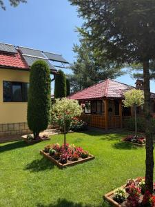 una casa con un patio con flores y árboles en Pensiunea Ana Maria, en Brad