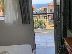 a bedroom with a bed and a view of a balcony at LAINAS apartments in Nea Skioni