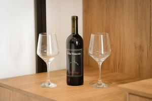a bottle of wine and two wine glasses on a table at Vila Venezia in Shëngjin