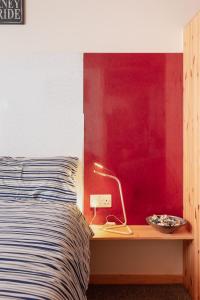 a bed with a lamp on a night stand next to it at Captains Rest in Whitby +1 photo