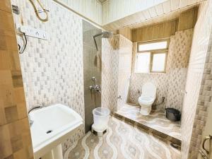 a bathroom with a toilet and a sink at Near Chauk Bazaar Marvel International & Restaurant HD Lama Rd in Darjeeling +44 photos