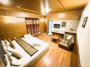 a large room with a bed and a living room at Near Chauk Bazaar Marvel International & Restaurant HD Lama Rd in Darjeeling