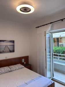 a bedroom with a bed and a large window at Apartman Karmela in Podgora
