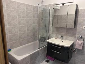 a bathroom with a shower and a sink and a tub at Apartman Karmela in Podgora