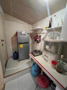 a small kitchen with a counter and a refrigerator at Mariel's Nest in Tigumal