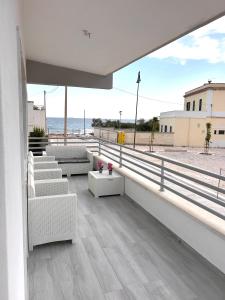 Un balcón con sofás y vistas al océano. en Villa PO, en Torre Santa Sabina