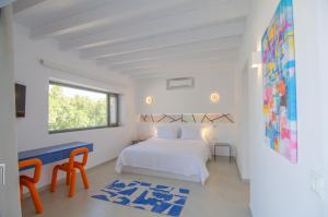 a white bedroom with a bed and a window at FarOut - BeachResort & Camping in Mylopotas