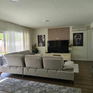 a living room with a couch and a flat screen tv at Villa Aqua Vista in Mostar