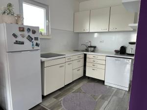 a kitchen with white cabinets and a white refrigerator at Villa Dalia in Gračanica