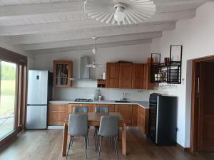 a kitchen with a table and chairs and a refrigerator at Country house pura natura Alghero in Casa Minnina