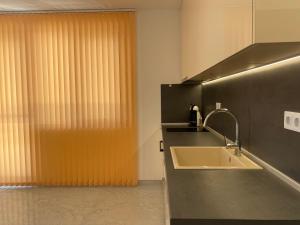 Baño con lavabo junto a una ventana en Blue Magenta 2, en Sozopol
