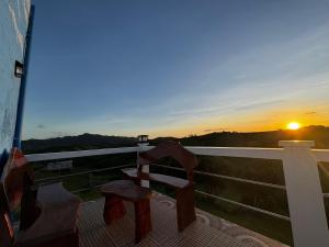 a balcony with a bench and the sunset in the background at Bryans Farmstead in Basco
