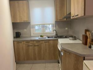 a kitchen with wooden cabinets and a sink at Katofli Holiday Home in Triovasálos +16 photos