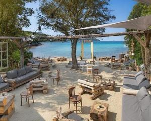 a patio with couches and chairs and the beach at BlueBay Oasis Deluxe Apartment in Fažana
