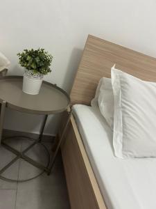 a bed with a table and a pillow and a plant at Katofli Holiday Home in Triovasálos